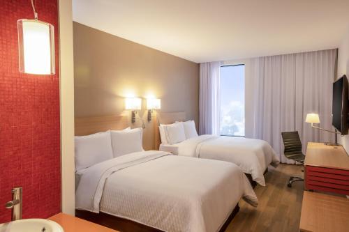 テポツォトゥランにあるフィエスタ インクアウティトランのベッド2台と窓が備わるホテルルームです。