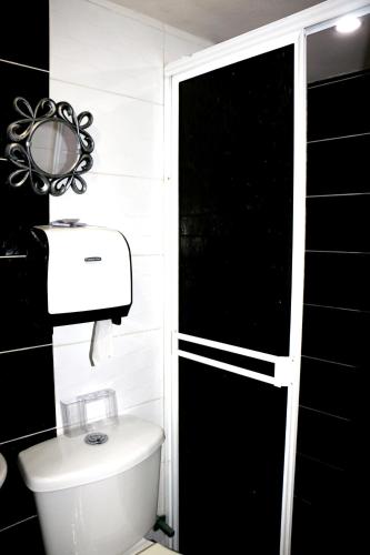a bathroom with a toilet and a black wall at Aparta Suite Torre De Prado 302 in Medellín