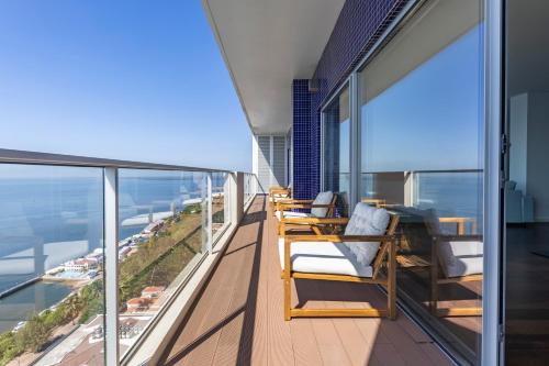 a balcony with two chairs and a view of the ocean at Xenon Urban Apartments in Maputo
