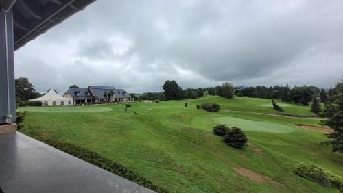 - une vue aérienne sur un parcours de golf avec une maison dans l'établissement Dilece, à Pouzac