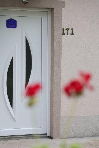a white door with a number on the side of a building at Apartman Nikolić in Kuršumlija