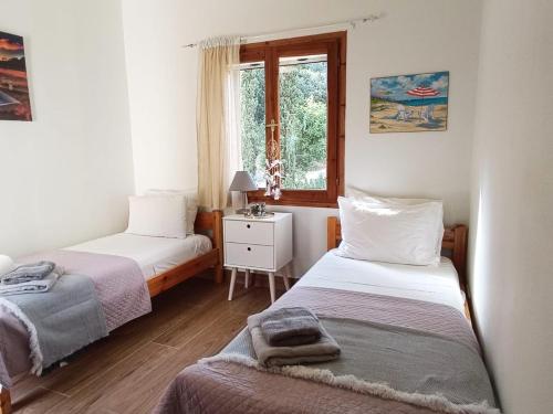 a small bedroom with two beds and a window at Villa Nova s.r Sea View in Porto Heli