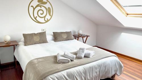 Un dormitorio con una cama grande con toallas. en The Cliffs - ViveMare, en Viveiro