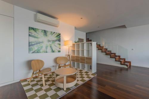 a living room with a table and chairs and a staircase at Xenon Urban Apartments in Maputo