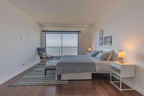 a bedroom with a bed and a large window at Xenon Urban Apartments in Maputo