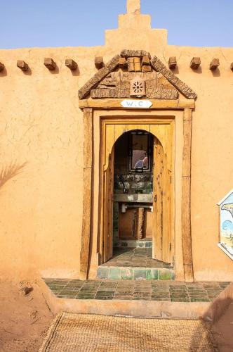 an entrance to a building with a sign on it at Auberge Kasbah Dar Sahara Tours in Mhamid