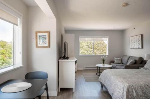 a bedroom with a bed and a living room at Gibsons Landing Inn in Gibsons