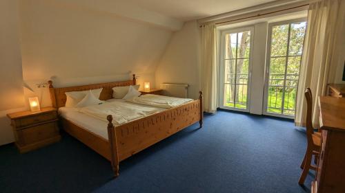 a bedroom with a bed and two lamps and windows at Gut Weihersmühle in Leutershausen