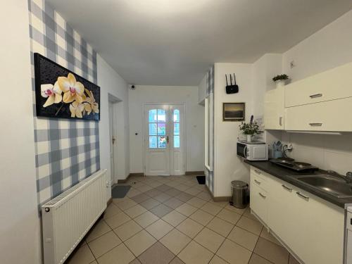 - une cuisine avec des placards blancs et un évier dans l'établissement Margarita Pokoje i Apartamenty, à Władysławowo