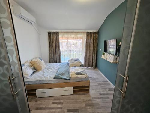 a small bedroom with a bed and a window at LaRenta Sveti Vlas, ulitsa Cherno more 12 in Sveti Vlas