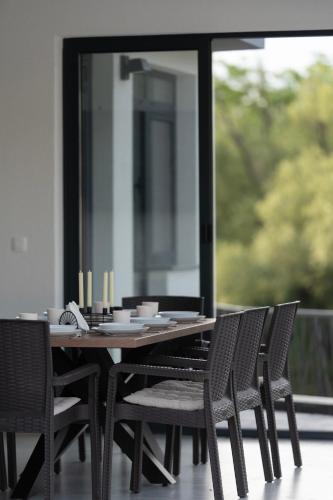 a dining table and chairs on a porch with a window at Villa H in Blagaj