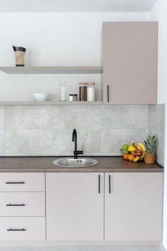 a kitchen with white cabinets and a sink at Villa H in Blagaj