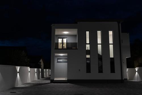 a white house with a door at night at Villa H in Blagaj