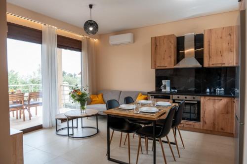 a kitchen and living room with a table and chairs at Terra Blue Suites - Dimitra in Kalyves