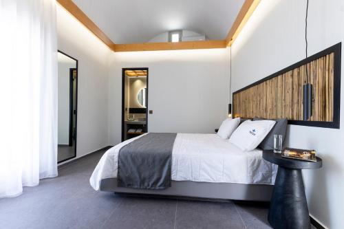 a bedroom with a large bed with a wooden headboard at William's Houses in Akrotiri
