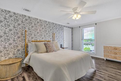 a bedroom with a bed and a ceiling fan at Penthouse Loft- Balcony Over Downtown Statesboro in Statesboro