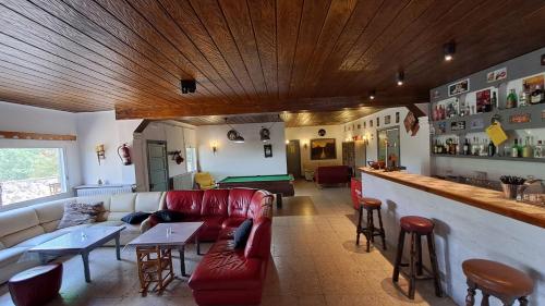 a living room with a red couch and a bar at Rural Sant Llop in Tordera