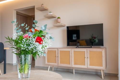 a vase of flowers sitting on a table in a living room at Terra Blue Suites - Dimitra in Kalyves
