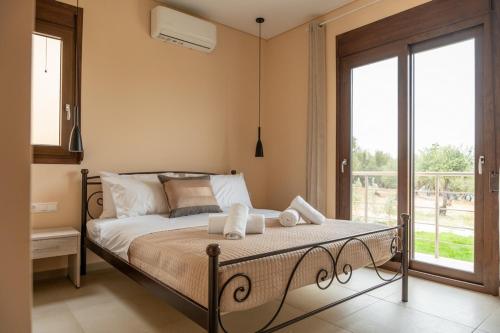 a bedroom with a bed and a large window at Terra Blue Suites - Dimitra in Kalyves