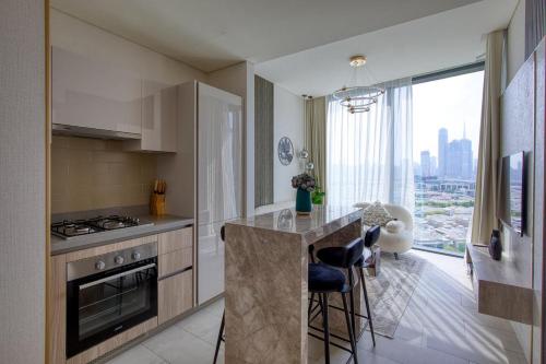 een keuken met een fornuis en een aanrecht met stoelen bij Apartment 1015 Waves in Dubai