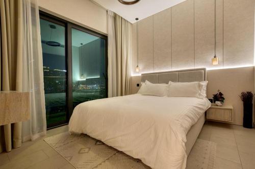 een slaapkamer met een groot bed en een groot raam bij Apartment 1015 Waves in Dubai
