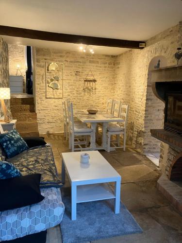 - un salon avec une table, une table et des chaises dans l'établissement Charmante maison en pierres, à Précy-le-Sec