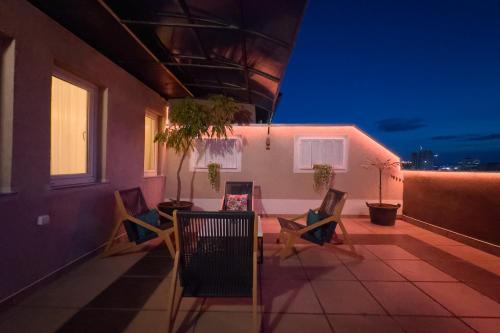 a balcony with chairs and a table on a building at Siera's Penthouse Twin in Pristina
