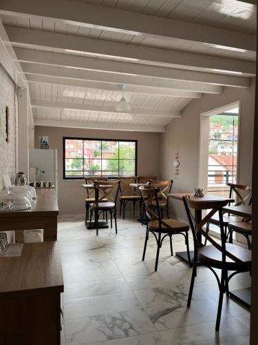 uma sala de jantar com mesas e cadeiras de madeira em Ora Apartament em Pogradec