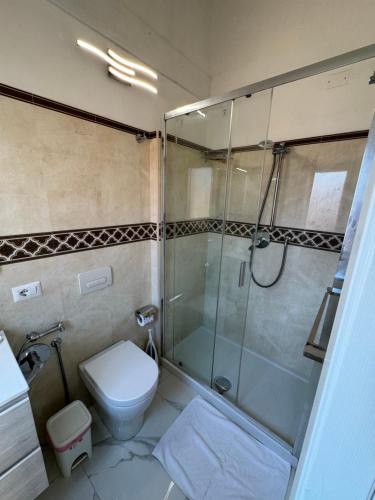 a bathroom with a glass shower and a toilet at Topazio Rooms & Apartment Tropea in Tropea