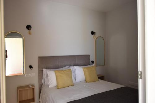 a bedroom with a bed with two mirrors on the wall at Family House in Lagos