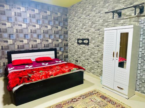 a bedroom with a bed with red sheets and red pillows at Royal Suite: King Comfort in Ajman 