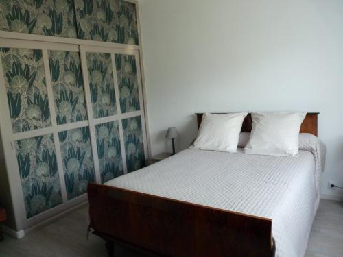 - une chambre avec un lit et un mur recouvert de papier peint dans l'établissement Appartement indépendant dans villa, entre Fréjus et St Raphaël, à Fréjus