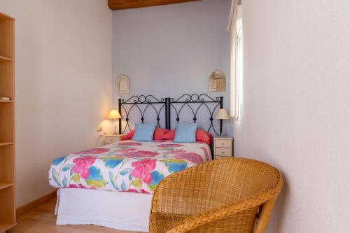 Un dormitorio con una cama y una silla de mimbre. en rentafive - Bungaló - Terraza - Parking, en Santa Pola