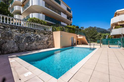 una piscina frente a un edificio en Mon Appart avec Terrasse et Piscine, en Roquebrune-Cap-Martin