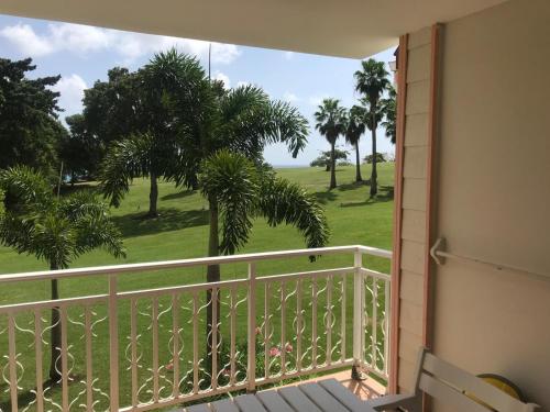 a balcony with a view of a golf course at la Désirade in Sainte-Luce