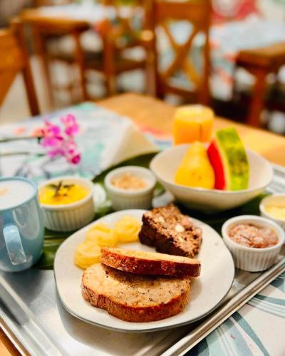 a plate of food with toast and fruit on a table at Smart Hotel Reserva Ilhabela in Ilhabela