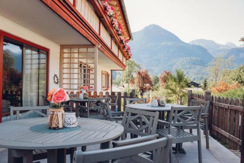 a patio with tables and chairs with mountains in the background at Gästehaus Germania in Schönau am Königssee