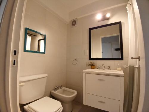 a white bathroom with a toilet and a sink at Palermo Madison in Buenos Aires