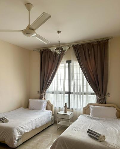 a bedroom with two beds and a window at SIRA apartment 1 in Muscat