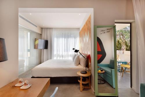 a bedroom with a bed and a table and a chair at Cucu Hotel By 7Minds in Tel Aviv