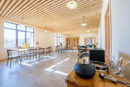 a room with tables and chairs and a room with windows at Hotel Kareta in Mestia