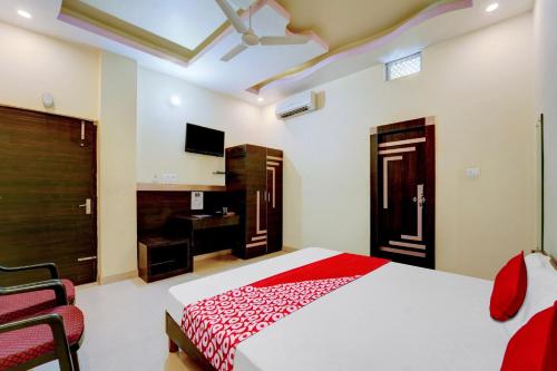 um quarto com uma cama grande e um cobertor vermelho em OYO Flagship Hotel Centre Point em Chupra