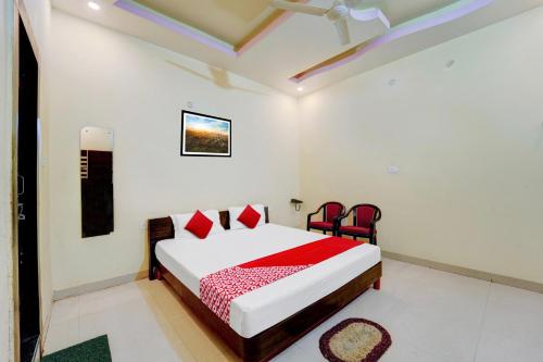a bedroom with a bed and two red chairs at OYO Flagship Hotel Centre Point in Chupra