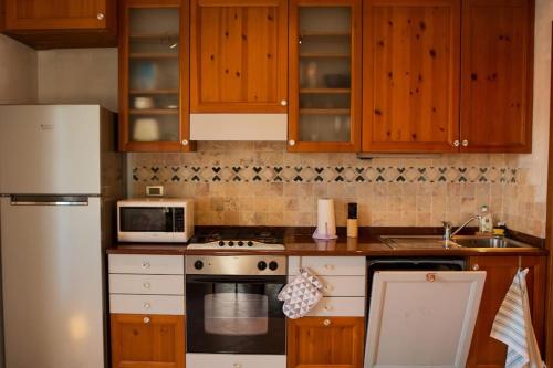 una cucina con armadi in legno e frigorifero bianco di Garda Casa Camelia a Sirmione