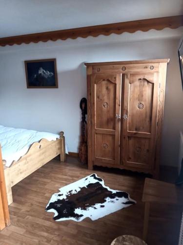 une chambre avec un lit et une armoire en bois dans l'établissement appartement parc aux etoiles, à Puy-Saint-Vincent