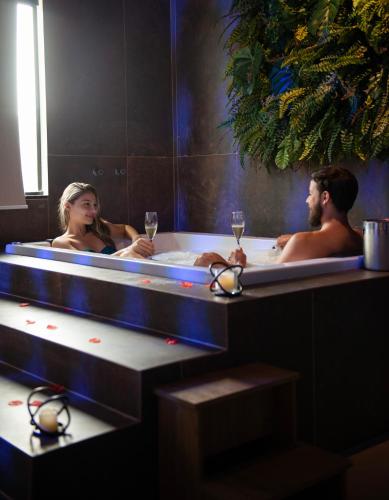 two people in a bath tub with glasses of wine at Zagaia Eco Resort in Bonito