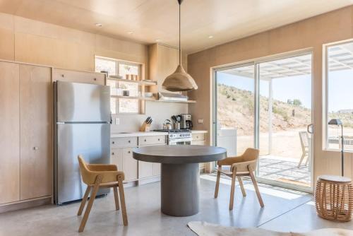 a kitchen with a refrigerator and a table and chairs at Pause House - AM - your break in Joshua Tree in Joshua Tree