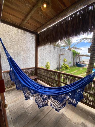 a hammock on the balcony of a house at Pousada Maré Cheia in Itarema