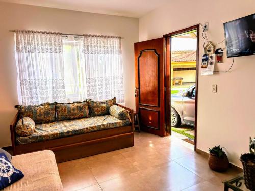 a living room with a couch in front of a window at Praia Martin de Sá SP. in Caraguatatuba