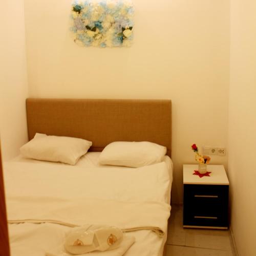 a small bedroom with a bed and a night stand at Sebilhan Apart Hotel in Sarajevo